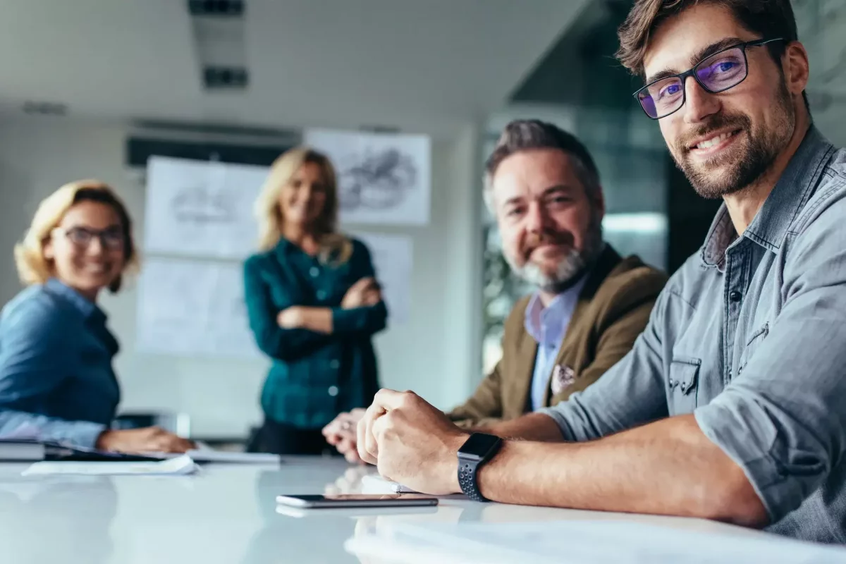 Professionnels en réunion d'affaires, un homme souriant au premier plan